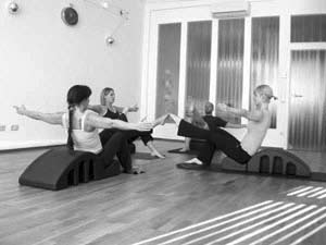 Gruppentraining auf dem Pilates Arc - Übung legstretch